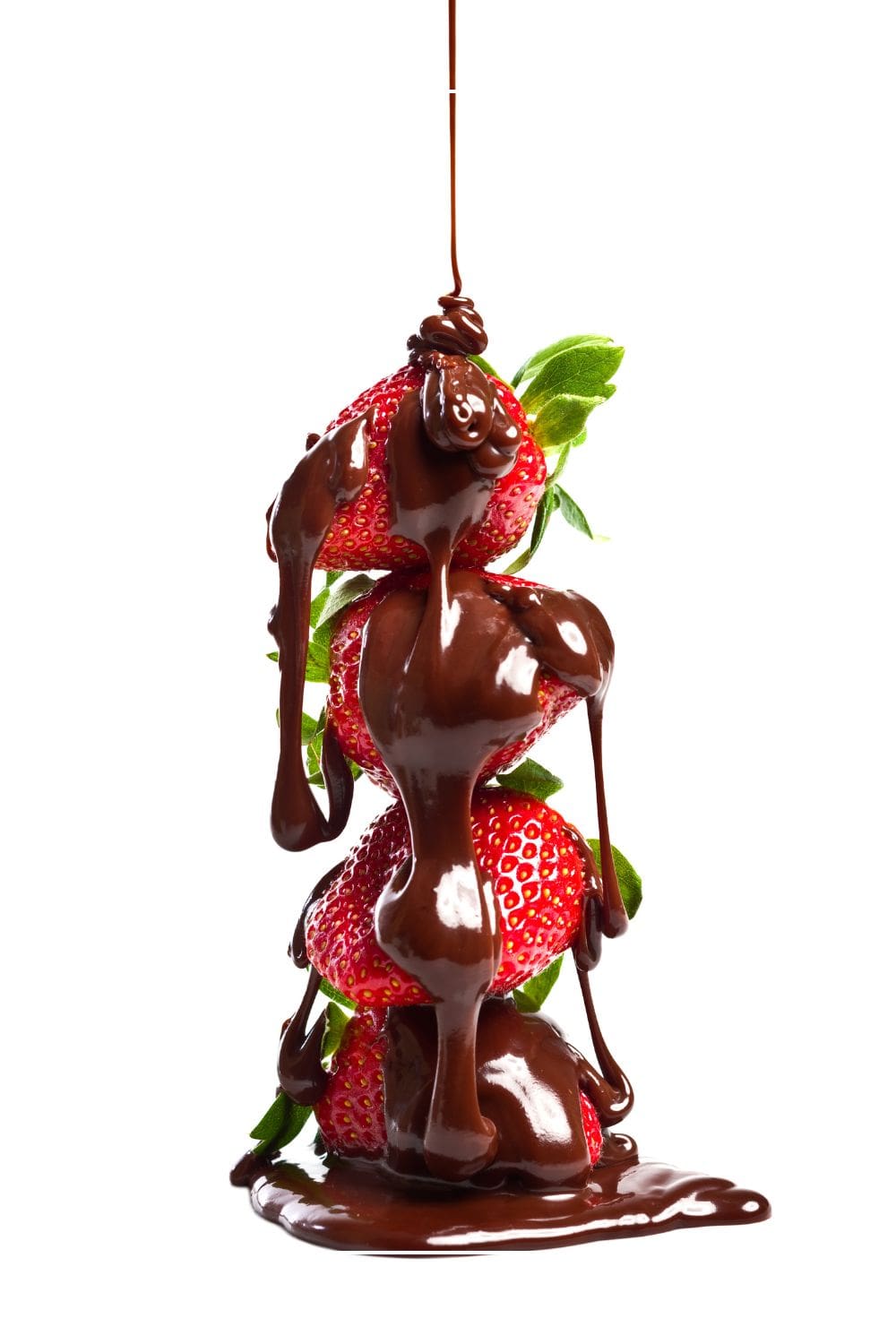 Drizzling chocolate syrup over a stack of fresh strawberries